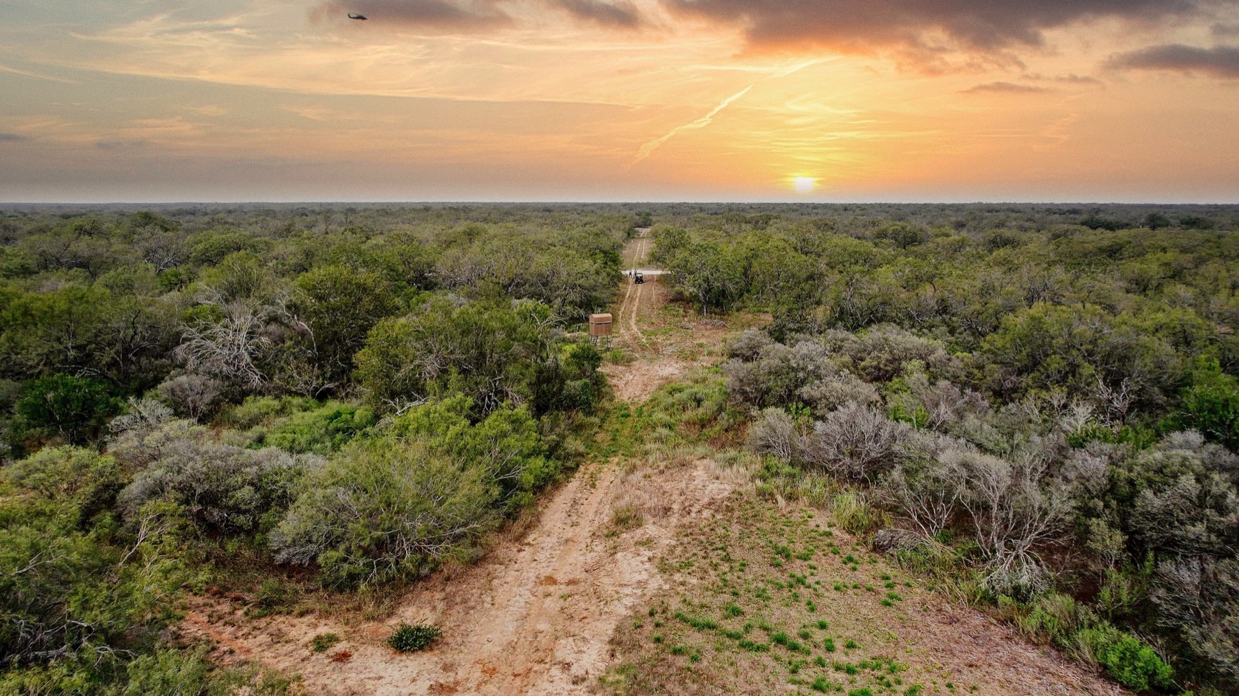 The Ranch at Camp Ka Hui 'Ana brand mark over South Texas brush country